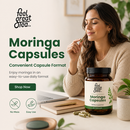 Woman holding a Moringa Capsule with 'feel great tea co.' branding on a table.